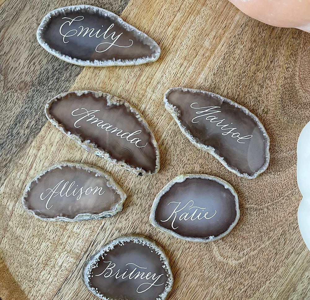 Close-up of engraved champagne flutes from a private party, featuring live calligraphy-style engraving on metal bases